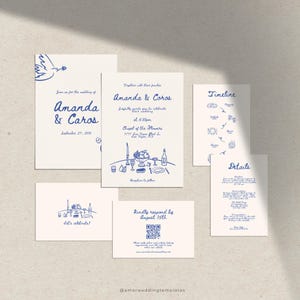 Op de afbeelding: Trouwkaartenset met blauwe illustraties op crèmekleurig papier. De uitnodiging toont "Amanda & Caros" met evenementdetails. Bevat een tijdlijn, een RSVP-kaart en een kaart met "Let's celebrate!"