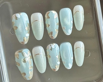 Unghie ovali dipinte a mano: acrilico effetto occhi di gatto con motivo floreale azzurro chiaro