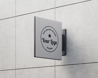 May include: A gray square sign with rounded corners is mounted to a white tiled wall. The sign has a black circle with a star and the text "Your Logo" in a stylized font. The text "Your Logo Will Be Here!" and "Slogan" are also printed on the sign.