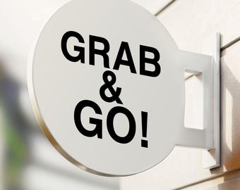 May include: White round sign with black text that reads "Grab & Go!" mounted on a white wall.