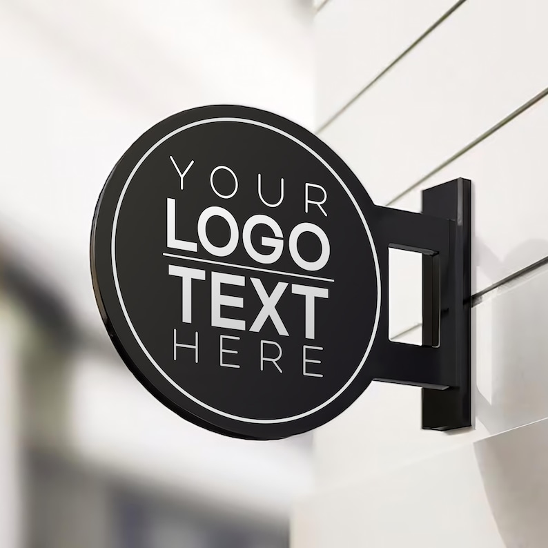 May include: Black circular sign with white text that reads "YOUR LOGO TEXT HERE" mounted on a white wall.