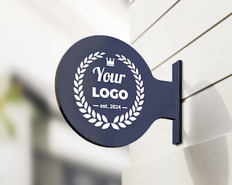 May include: A circular dark blue wall-mounted sign featuring a white laurel wreath graphic surrounding the text Your LOGO and est. 2024 with a small crown icon at the top. The sign is attached to a vertical bracket extending from a white wall.