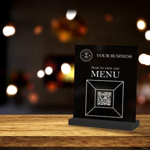 May include: Black sign with a white QR code and the text "YOUR BUSINESS Scan to view our MENU".