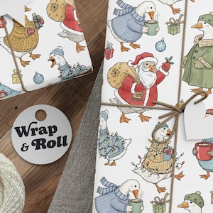 A gift wrapped in cute Christmas goose wrapping paper, featuring a whimsical pattern of geese dressed in sweaters, Santa hats, and tangled in lights on a white background. The present is tied with twine and surrounded by pine branches, creating a funny and festive look.