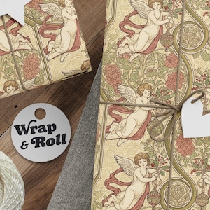 Puede incluir: Regalos envueltos con papel decorativo con ángeles y motivos florales. Cada paquete está atado con hilo y una etiqueta blanca. También se ven una madeja de hilo, tijeras y etiquetas. La etiqueta redonda dice "Wrap & Roll".