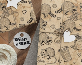Könnte beinhalten: Geschenkverpackungen mit Papier im Waschbären-Design, mit Bindfaden gebunden und mit stern- und herzförmigen Anhängern verziert. Eine Garnrolle, eine Schere und Anhänger sind ebenfalls vorhanden. Das Papier hat ein sich wiederholendes Muster aus Waschbären, Mülleimern und Herzen.