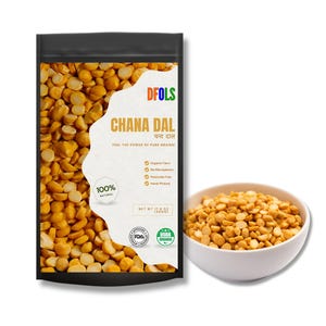 Puede incluir: Una bolsa negra de Chana Dal DFOLS, con el texto "CHANA DAL" y "FEEL THE POWER OF PURE GRAINS!". La bolsa contiene garbanzos partidos amarillos. Un cuenco blanco lleno de Chana Dal está al lado de la bolsa. La bolsa está etiquetada como "100% NATURAL" y "NET WT 500g".