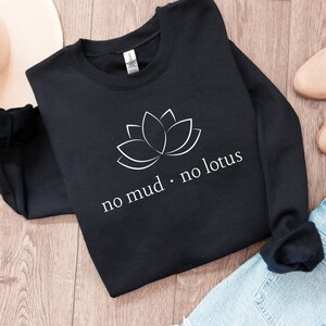 May include: Black sweatshirt with a white lotus flower graphic and the text "no mud. no lotus".