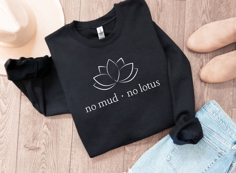 May include: Black sweatshirt with a white lotus flower graphic and the text "no mud. no lotus".