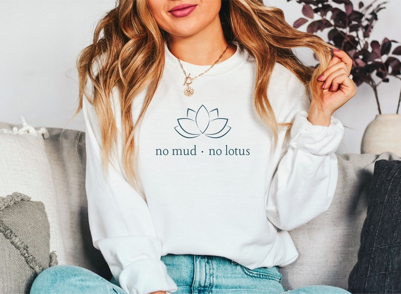 May include: White sweatshirt with a blue lotus flower graphic and the text "no mud. no lotus".