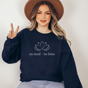 May include: A navy blue sweatshirt with a white lotus flower graphic and the text "no mud. no lotus".