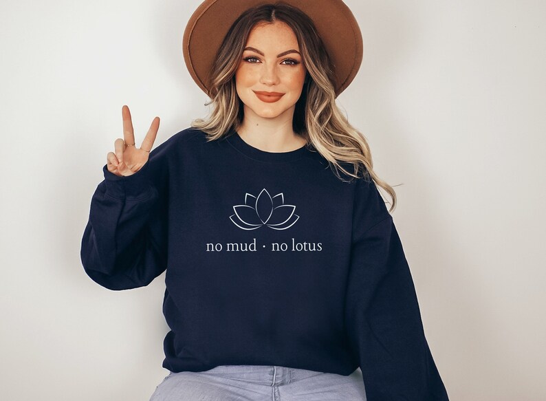 May include: A navy blue sweatshirt with a white lotus flower graphic and the text "no mud. no lotus".