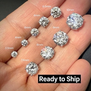 May include: A collection of round, brilliant-cut clear stud earrings arranged by size, labeled with measurements from 3.5mm to 10mm. Each earring features a multi-faceted stone set in a silver-toned metal prong setting, showcasing a clear, reflective surface.