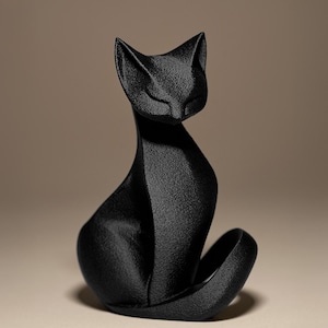 May include: A black cat figurine in a seated position with its tail curled. The cat has a sleek, modern design with a textured surface. The figurine is a solid black color and sits on a neutral background.