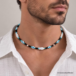 Puede incluir: Un collar tipo gargantilla con cuentas cilíndricas negras, pequeñas cuentas redondas turquesas, cuentas blancas de ojo con centros azules y negros, y dijes blancos en forma de pez, todo ensartado en un cordón flexible.