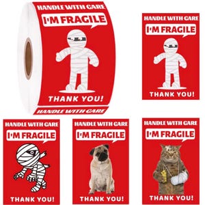 May include: A roll of red and white shipping labels with the text "HANDLE WITH CARE" and "I'M FRAGILE". The labels feature a mummy, a pug, and a cat with a broken arm. The labels also say "THANK YOU!"