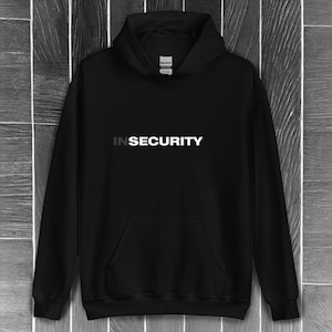 May include: Black hooded sweatshirt with the text "INSECURITY" in white letters on the front.