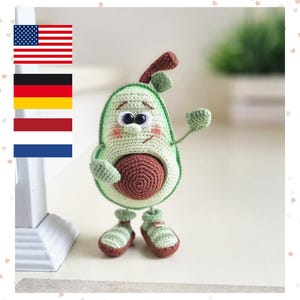 Può includere: Un peluche a forma di avocado realizzato all'uncinetto con un corpo verde chiaro, un nocciolo centrale marrone scuro e un piccolo stelo marrone sulla parte superiore. Il pupazzo ha occhi in plastica nera, sopracciglia ricamate e scarpe a righe.