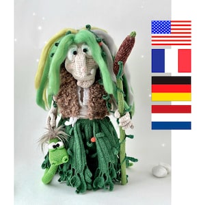 Puede incluir: Una muñeca de gnomo de crochet verde y marrón con cabello largo verde, sosteniendo un palo verde y una pequeña serpiente de crochet verde. El gnomo lleva un chaleco marrón y una falda verde.