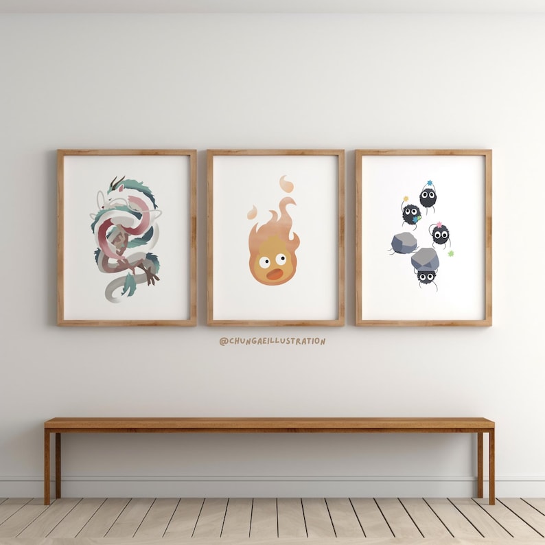 May include: Three framed art prints featuring illustrations of a dragon, a fire spirit, and soot sprites. The dragon is depicted in shades of blue, pink, and white. The fire spirit is orange and yellow. The soot sprites are black with party hats.