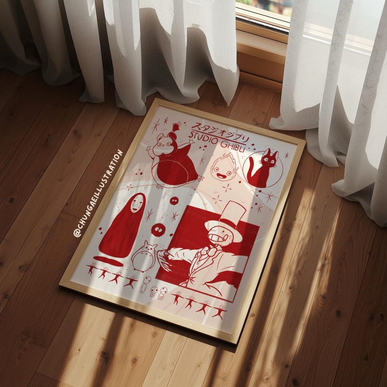 May include: A framed art print featuring red illustrations of Studio Ghibli characters on a white background. The print includes characters like Totoro, No-Face, and Howl, with Japanese text at the top. The frame is a light wood color.