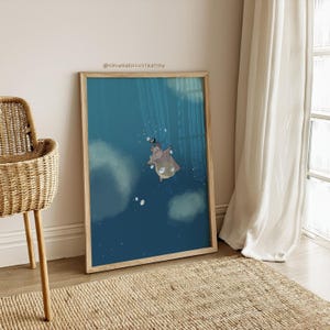 May include: A framed art print depicting a cartoon hippo floating in a blue underwater scene. The hippo wears a hat and cape. The print is in a wooden frame. The artwork is displayed on a wall, next to a window with white curtains.