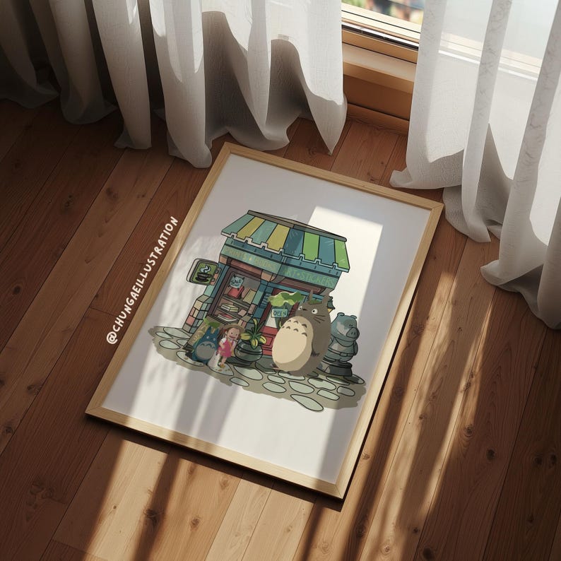 May include: A framed print featuring a colorful illustration of a shop with a green and yellow striped awning. The artwork includes characters from the animated film "My Neighbor Totoro", including Totoro and Mei. The print is displayed on a wooden floor.