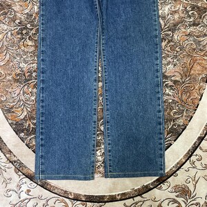 Puede incluir: Un par de vaqueros de mezclilla azules. Los vaqueros tienen un dise&ntilde;o cl&aacute;sico de cinco bolsillos, una pernera recta y un lavado medio. Los vaqueros est&aacute;n hechos de una tela de mezclilla duradera y son adecuados para el uso diario.