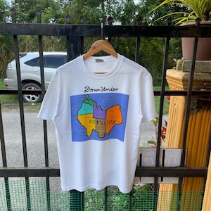 May include: White t-shirt featuring a cartoon map of Australia with the text "Down Under" printed on the front.