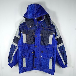 May include: A blue and black hooded jacket with a geometric pattern. The jacket has multiple pockets and a zipper closure.
