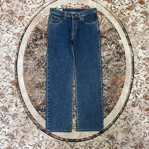 Puede incluir: Vaqueros de mezclilla azules con un dise&ntilde;o cl&aacute;sico de cinco bolsillos. Los vaqueros tienen un corte de pierna recta y cierre de bot&oacute;n y cremallera. La mezclilla tiene un lavado medio con detalles sutiles de desvanecimiento y bigotes.