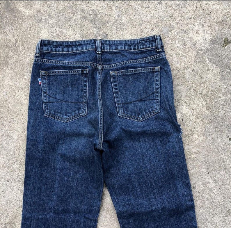 Op de afbeelding: Een paar donkerblauwe spijkerbroeken met een vervaagde look. De jeans heeft vijf zakken, waaronder twee achterzakken met stiksels.