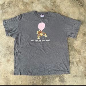 May include: A grey t-shirt featuring a cartoon monkey holding onto a pink balloon. The shirt has the text "Don't Swallow Your Gum!" printed on it.