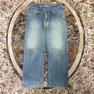 May include: Light blue denim jeans with a classic five-pocket design. The jeans have a faded wash and a straight leg fit. The jeans are made of a durable denim material and feature a button and zipper closure.