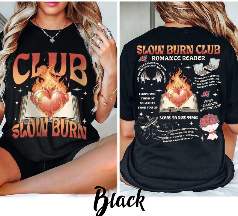 May include: Black t-shirt with a graphic design featuring the text "CLUB SLOW BURN" in orange and white, with a heart-shaped flame over an open book. The back of the shirt has additional text and graphics.