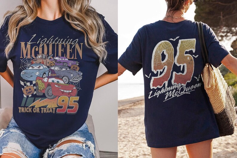 K&ouml;nnte beinhalten: Marineblaues T-Shirt mit einem Aufdruck von Lightning McQueen und anderen Cars-Charakteren, dem Text "Trick or Treat" und "95". Auf der R&uuml;ckseite des Shirts ist eine gro&szlig;e "95" und der Text "Lightning McQueen" zu sehen.