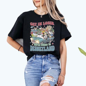 Puede incluir: Camiseta negra con un gr&aacute;fico colorido que presenta a Mickey Mouse, Minnie Mouse, Donald Duck y Goofy en un coche vintage. El texto dice "GET IN LOSER WE'RE GOING TO DISNEYLAND" en una fuente retro. Estrellas e im&aacute;genes del parque Disney completan el dise&ntilde;o.