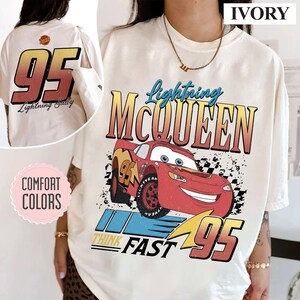 May include: Ivory-colored t-shirt featuring Lightning McQueen from the Cars movie. The front graphic includes McQueen, the number 95, and the words "Think Fast." The back of the shirt displays the number 95 and "Lightning Sally."