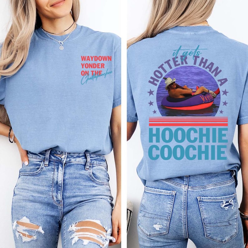 May include: Light blue t-shirt with text on the front and back. The front says "WAYDOWN YONDER ON THE Chattahoochee" in red and blue. The back says "it gets HOTTER THAN A HOOCHIE COOCHIE" with a graphic of a person in a tube.