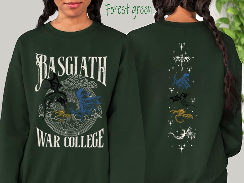 Puede incluir: Sudadera verde bosque con texto "Basgiath War College" y gr&aacute;ficos de dragones. La parte delantera presenta un dise&ntilde;o circular con dragones negros, azules y amarillos. La parte trasera muestra una l&iacute;nea vertical de ilustraciones de dragones en blanco, azul, negro, dorado y blanco.