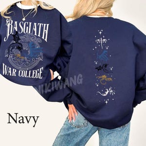 Puede incluir: Sudadera azul marino con texto "Basgiath War College" y gr&aacute;ficos de dragones en la parte delantera. La parte trasera presenta siluetas de dragones. La palabra "Navy" est&aacute; en la parte inferior. Una prenda c&oacute;moda e informal.