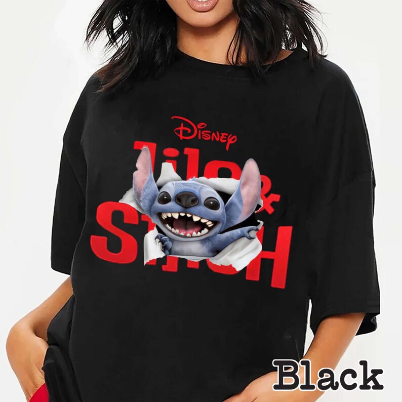 Puede incluir: Camiseta negra con un gr&aacute;fico del personaje de Disney Stitch rompiendo un efecto de papel rasgado. El logotipo de Disney y "Lilo & Stitch" son rojos. La palabra "Black" est&aacute; impresa en la parte inferior.