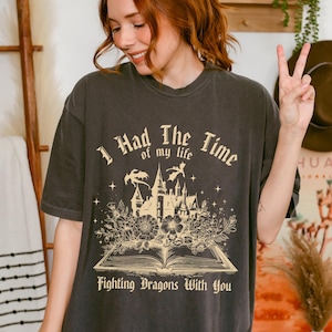 May include: Dark grey t-shirt featuring the text "I Had The Time of my life Fighting Dragons With You" and a castle graphic with flowers and dragons. The shirt has a relaxed fit.