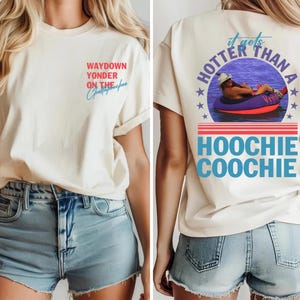 May include: Cream-colored t-shirt with text on the front and back. The front says "Waydown Yonder on the Chattahoochee" in red and blue. The back says "It gets hotter than a Hoochie Coochie" with a graphic of a person in a tube.