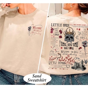 May include: Sand-colored sweatshirt with gothic-style text and graphics. The front features a rose and the words "Welcome to Hell, Little Darling." The back displays a skull with a crown, roses, and phrases like "Little One" and "I vow, you vow, we vow."