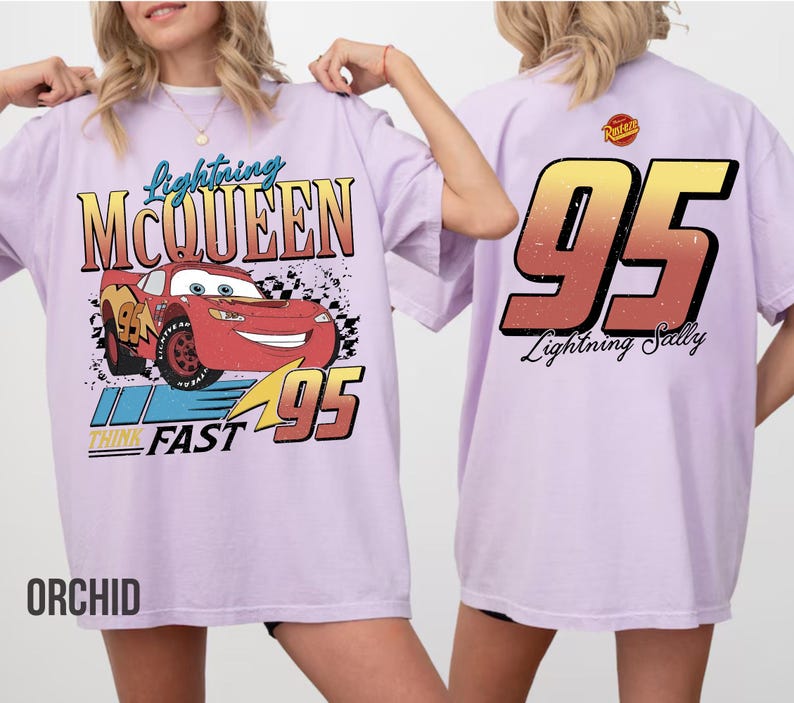 May include: Orchid-colored t-shirt featuring Lightning McQueen from the Cars movie. The front graphic includes the character, the number 95, and the words "Lightning McQueen" and "Think Fast." The back of the shirt displays the number 95 and the words "Lightning Sally."
