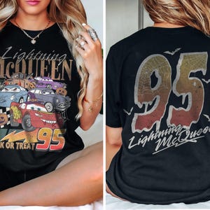 K&ouml;nnte beinhalten: Schwarzes T-Shirt mit einer Grafik von Lightning McQueen und anderen Cars-Charakteren, dem Text "Trick or Treat" und "95". Auf der R&uuml;ckseite des Shirts sind "95" und "Lightning McQueen" abgebildet.