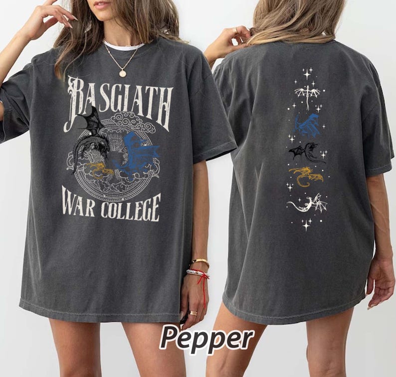 Puede incluir: Camiseta gris oscuro con el texto "BASGIATH WAR COLLEGE" y un gr&aacute;fico de drag&oacute;n. La parte trasera de la camiseta presenta un dise&ntilde;o vertical con m&uacute;ltiples ilustraciones de dragones en varios colores. La palabra "Pepper" est&aacute; impresa en la parte inferior.