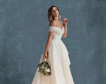 Vestido de novia evasé de encaje con pedrería y hombros descubiertos con espalda con cordones