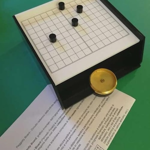 Può includere: Un gioco da tavolo Peggotty Board con cornice nera, griglia bianca e pioli neri. Sono presenti anche un disco color oro e istruzioni stampate. Il gioco da tavolo è progettato per una forma di gioco unica.